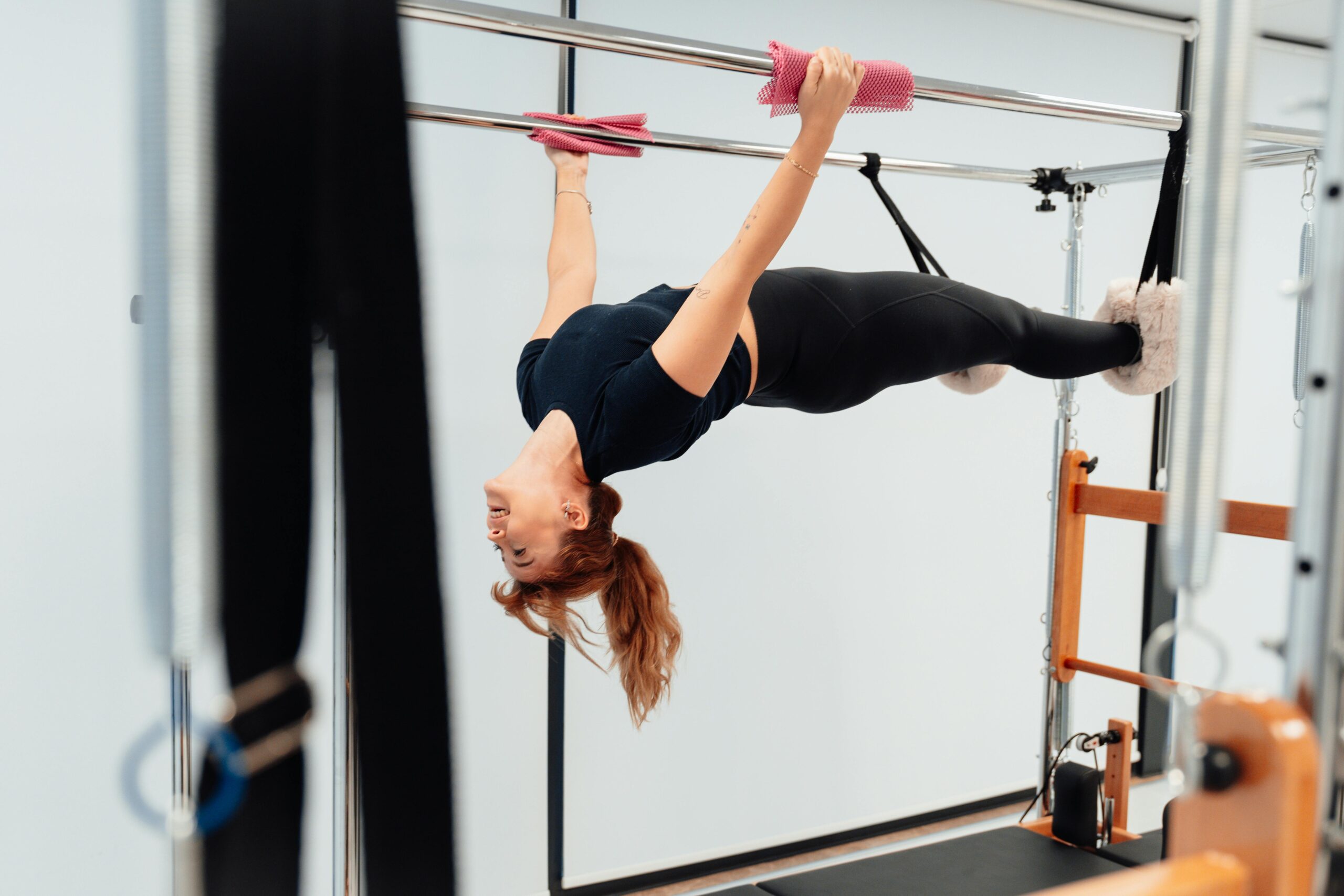 Woman performing a pilates exercise on a Cadillac machine indoors in Yalova, Türkiye, showcasing fitness and strength.